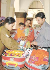 Delhi Police personnel checking the luggage of passengers at Old Delhi Railway Station