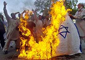 Activists of the Islamic National Front burn Israeli and US flags as they shout slogans during a protest against Israel's controversial archaeological excavation near Jerusalem's Al-Aqsa mosque in Karachi on Friday