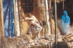 MCD men demolishing structures at INA Market in front of Dilli Haat in the Capital on Tuesday