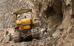 Men and machine of the Border Roads Organisation (BRO) clear the Jammu-Srinagar National Highway of landslides that have blocked the road for the past seven days, at Panthal on Tuesday