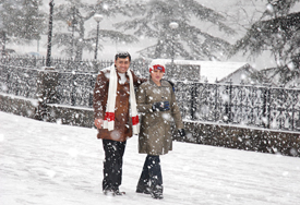 A couple enjoys the snowfall at the Ridge in Shimla on Wednesday.