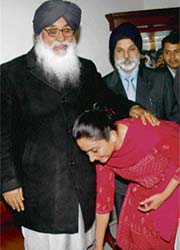 Harsimrat Kaur, daughter-in-law of Parkash Singh Badal, touches his feet on arrival at his residence in Chandigarh from Badal village