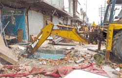 Demolition goes on at INA Market in front of Dilli Haat in the Capital on Thursday