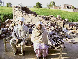 A septuagenarian couple, Mohinder Singh and Lakhbir Kaur, sit in front of their house, allegedly demolished by SAD workers at Haruwal village in the Fatehgarh Churian area of Gurdaspur.