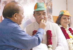 BJP Delhi Pradesh president Dr Harsh Vardhan offering sweets to Bhim Singh at a press conference in the Capital on Tuesday.
