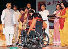 Faridabad's Shivani Gupta receives a shawl on the occasion of International Women's Day while Chief Minister Bhupinder Singh Hooda looks on at the Indradhanush Auditorium, Sector 6, Panchkula