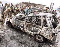 Police officers remove a burnt car after an attack by a mob outside a local restaurant in Srinagar on Friday. The mob attacked and ransacked a local restaurant which they said was being used for immoral activities