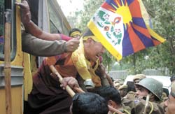 Policemen try to control an activist of Tibetan Youth Congress as they detain him during a protest on the occasion of 48th anniversary of Tibetan National Uprising Day, near the entrance to the Chinese embassy in the Capital