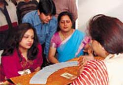 MORE THINGS IN HEAVEN AND EARTH: A family trying to know their future through tarot cards during the ongoing Nakshatra 2007 exhibition in the Capital on Sunday. A Tribune Photograph