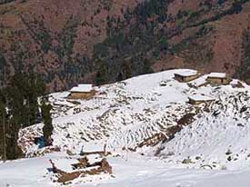 A view of temporary houses of Gujjars covered with fresh snow near Prashar Lake in Mandi district on Sunday