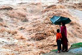 Two children watch the fury of the Tawi which was flowing above the danger mark in Jammu on Monday