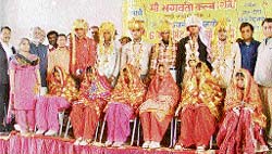 Newly wed brides sit coyly with their grooms at a marriage function in Ludhiana on Sunday. The Maa Bhagwati Club arranged the marriage of six girls from economically weaker families