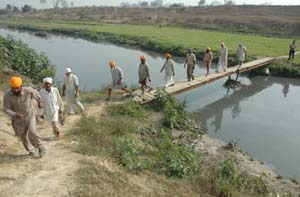 Dauke residents cross a bridge to reach their fields across the fence on the Indo-Pak border. 