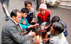 With a cold wave sweeping Himachal Pradesh following rain and snow for three consecutive days, shopkeepers huddle around a bonfire in Shimla