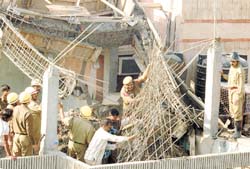 Delhi Police and fire personnel removing the debris of a house under construction which collapsed, injuring four labourers at East of Kailash in the Capital