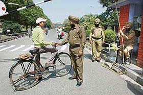 A security man questions a cyclist at the entry gate of Guru Nanak Dev University