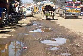 Deep potholes on the Pathankot-Gurdaspur-Amritsar highway at Dina Nagar that has turned into virtual death trap for commuters