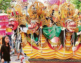 A Balinese girl looks at a float symbolising evil dufing a Hindu ritual in Kuta, Bali