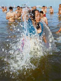 A woman devotee takes a holy dip at Sangam during a solar eclipse in Allahabad