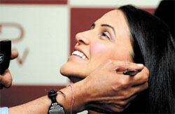 Cinestar Neha Dhupia receives finishing touches from noted make-up artiste Jojo, not in the frame, before making an appearance at the ongoing Wills India Fashion Week.