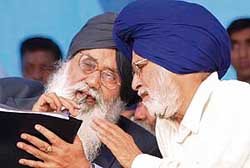 Punjab Chief Minister Parkash Singh Badal discusses a point with Deputy Speaker of the Lok Sabha Charanjit Singh Atwal