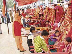 A woman and her children offer prayers to hill gods at the Devta Fair in Sundernagar on Sunday. 