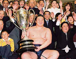 Mongolian ozeki-ranked sumo wrestler Hakuho, flanked by his supporters, holds the Emperors Cup after beating grand champion Asashoryu in a playoff in the Spring Grand Sumo Tournament in Osaka.
