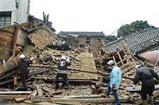 Rescue workers search for victims in the debris of a collapsed house in the city of Wajima, in Ishikawa prefecture, after a massive earthquake hit northern Japan on Sunday