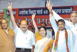 BJP leader Sushma Swaraj and president of its Delhi unit Dr Harsh Vardhan join S Bhardwaj, candidate for the MCD polls from Ashok Vihar, at a public meeting in Wazirpur Industrial Area in the Capital