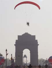 A paraglider is silhouetted against the sky over India Gate before alighting as part of Run for Military Game 2007 on Tuesday