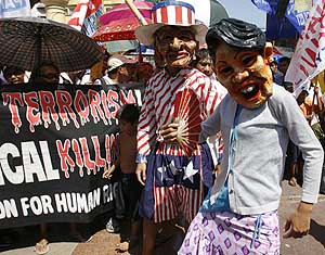 Protesters wearing masks of Philippine President Gloria Macapagal Arroyo and US President George W. Bush parade during a rally in Manila on Tuesday. 