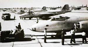 IAF ground crew work on a Canberra B(I) Mk 58 at an airbase shared with C-119 Packet transport aircraft (in the background)