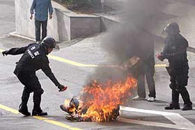 Policemen use fire extinguishers on a man who set himself ablaze in front of a hotel, the venue for the South Korea-US free trade agreement talks, in Seoul on Sunday.