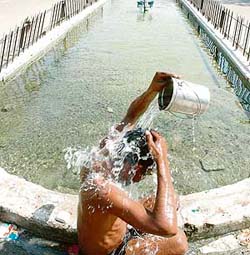 With the mercury rising, a man beats the heat with fountain water on the Club Road in Ludhiana