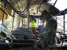 A Sri Lankan soldier looks at the wreckage of a bus after a parcel bomb explosion which killed at least 16 people and wounded 25 others in the eastern district of Ampara on Monday