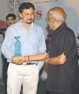 BSES Hindi editor Chandra Prakash Kamath accepting the award from Chairman of National News Service Kesar Gupta