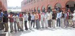 Voters wait in a long queue to cast their votes at a polling booth