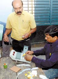 Officials repairing an electronic voting machine that developed snag at the start of the polling in Karol Bagh in the Capital on Thursday.