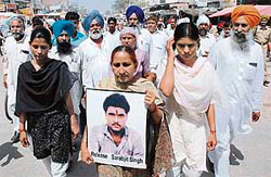 Dalbir Kaur, sister of Sarabjit Singh, accompanied by his daughters, proceeds towards the main chowk of Bhikhiwind for sitting on an indefinite fast.