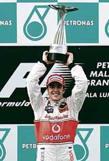 McLarens Formula One driver Fernando Alonso of Spain lifts the trophy after winning the Malaysian Grand Prix in Sepang.