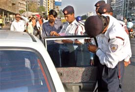 A car sporting tinted glasses being booked by traffic police personnel for violation of new norms which came into effect on Monday.