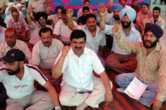 Members of the Johal Market Association hold dharna in Jalandhar on Monday.
