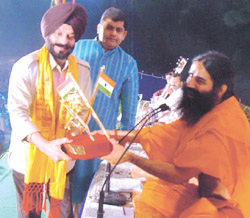 M. S. Bitta, Chairman of the Anti-Terrorist Front, felicitates Yoga exponent Swami Ramdev with Yoga Kranti Purush Award for his outstanding contribution to national interest at a yoga health camp held in the Capital 