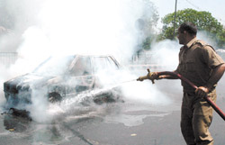 Fire personnel extinguishing the fire which broke out in a car near ISBT in the Capital