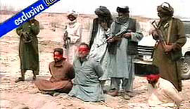A TV grab of exclusive footage, aired on the Italian RAI state television TG1 newscast on Tuesday, shows Italian journalist Daniele Mastrogiacomo (bottom centre), his driver, Sayed Agha (right), and interpreter Ajmal Naqshbandi, kneeling blindfolded before some gun-wielding Taliban militants.