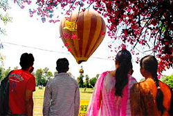 Students watch a hot air balloon show at the Jammu University campus during the first day of the Jammu heritage festival on Friday.