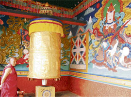 Bhutan is the last surviving Mahayana Buddhist state. A lama beside a giant prayer wheel.