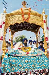 A decorated golden palanquin carrying Guru Granth Sahib leads a procession to mark the birth anniversary of Guru Tegh Bahadur in Amritsar on Tuesday. 