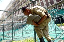 A CISF man passing through the construction-support pillars that collapsed due to a squall at Nirman Bhavan 