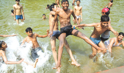 Children cool themselves in the artificial lake as temperature soars up at Boat Club near India Gate in the Capital